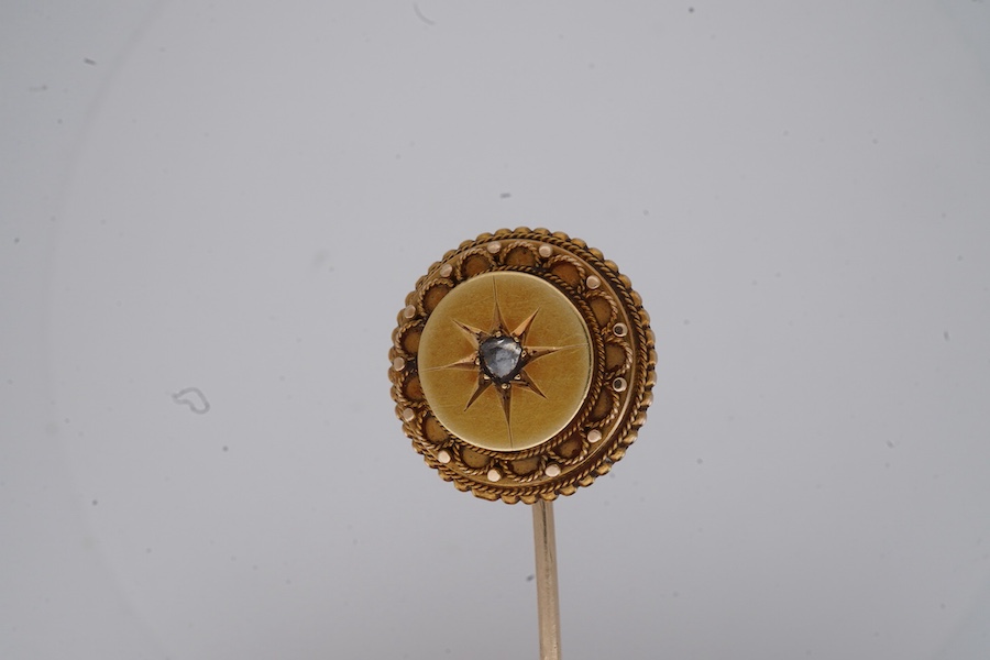 A Victorian gold and diamond stick pin, late 19th century, of circular outline with rope twist and grainti decoration, centring on a rose-cut diamond, length 7cm, gross weight 3 grams